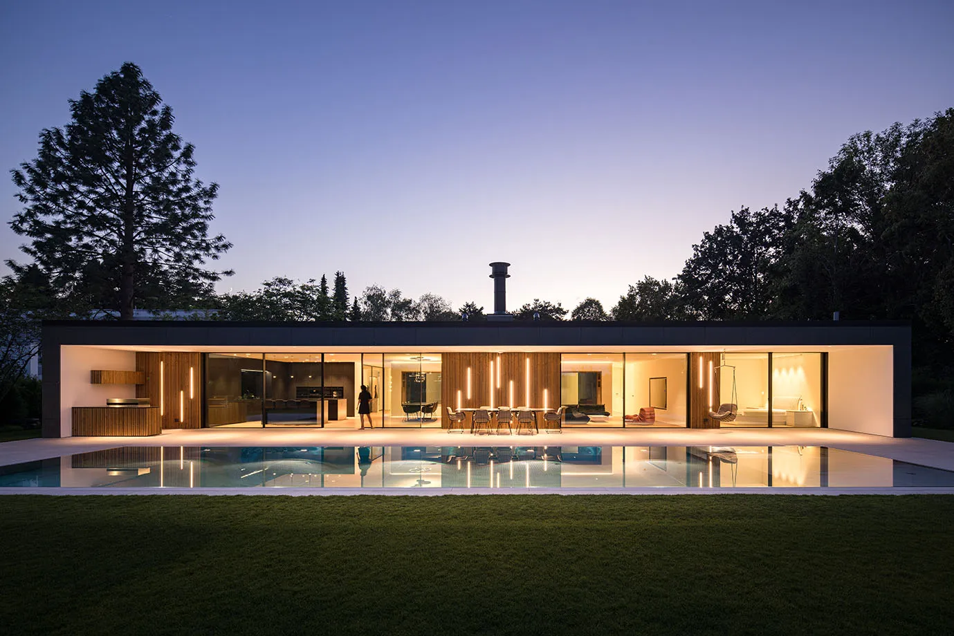 Moderner Neubaugarten mit Pool – Haus und Pool zur blauen Stunde